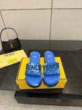 Fendi women's blue slide sandals with FF logo straps, shown with yellow shoebox.