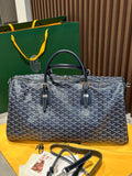 Goyard duffel bag with navy patterned canvas, leather handles, and front zip pockets