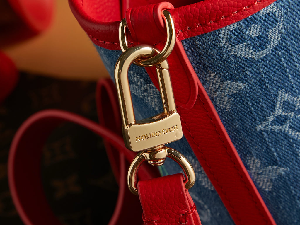 Red leather strap with gold clasp and Louis Vuitton logo on denim bag