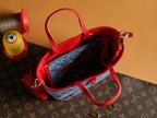 Denim tote bag with red handles, open top showing interior and zip pocket