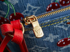 Gold zipper pull with Louis Vuitton logo on denim bag