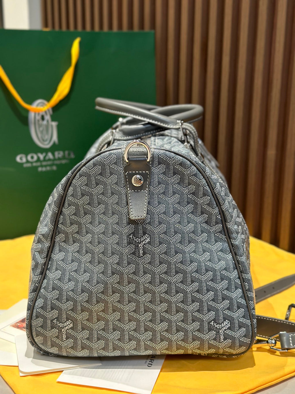 Grey patterned small duffel bag with single top handle and zip front
