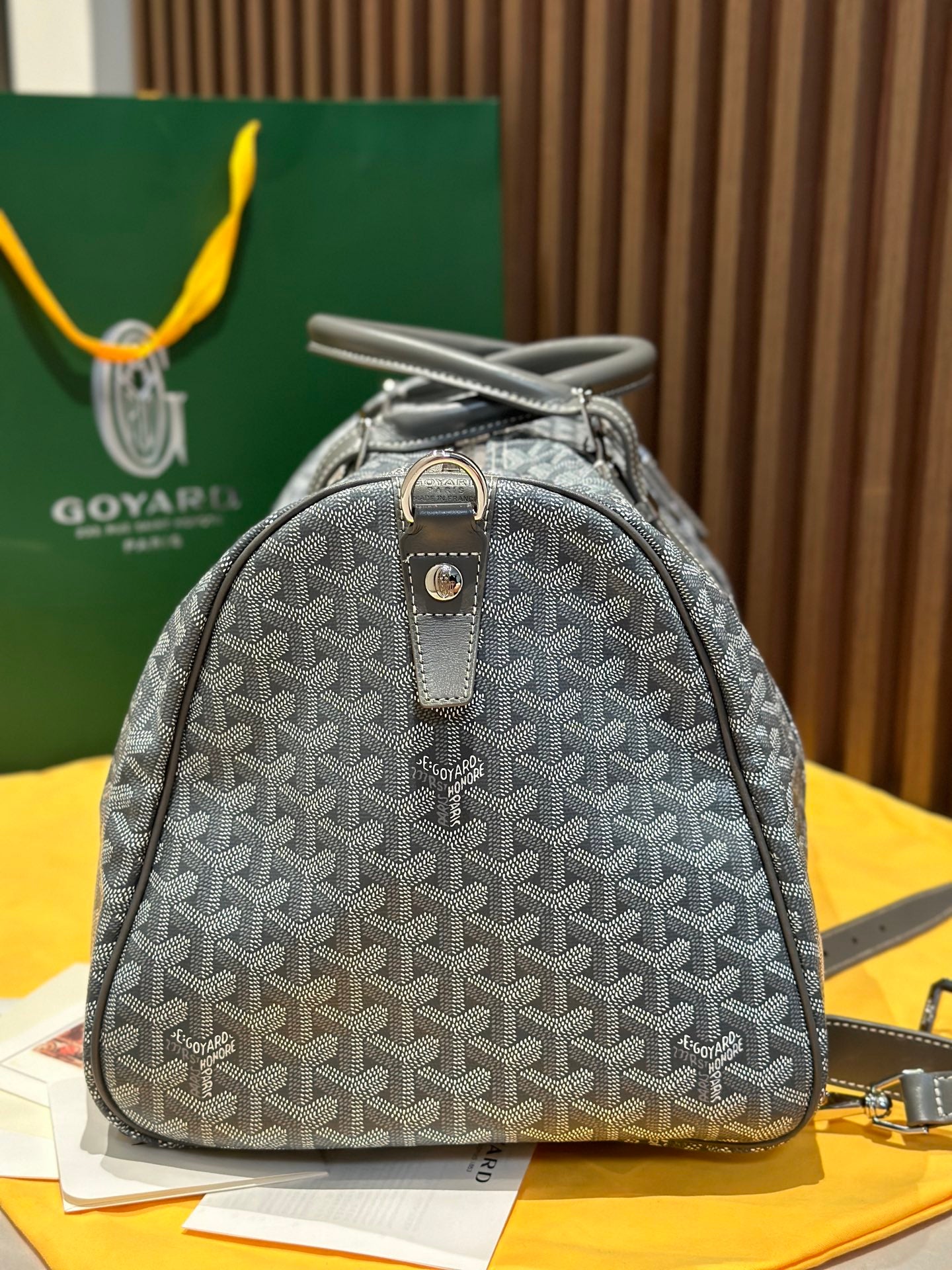 Grey patterned small duffel bag with single top handle and zip front