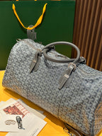 Grey patterned duffel bag with top handles and zip closure, shoulder strap