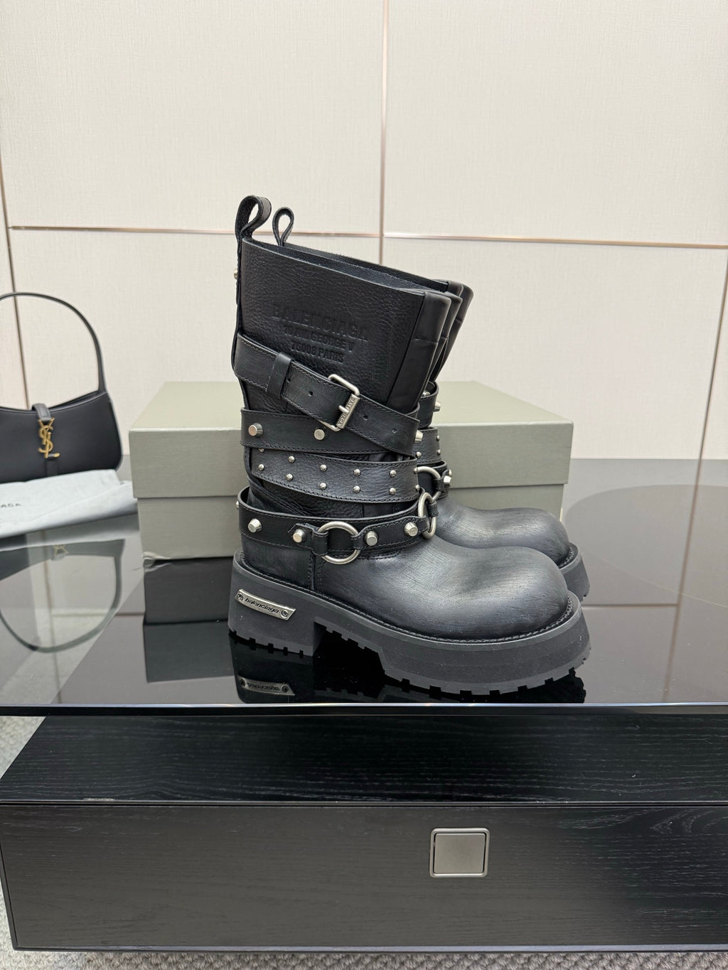 Black studded ankle boots with double straps and circular buckle, front view