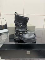 Black studded ankle boots with double straps and circular buckle, front view