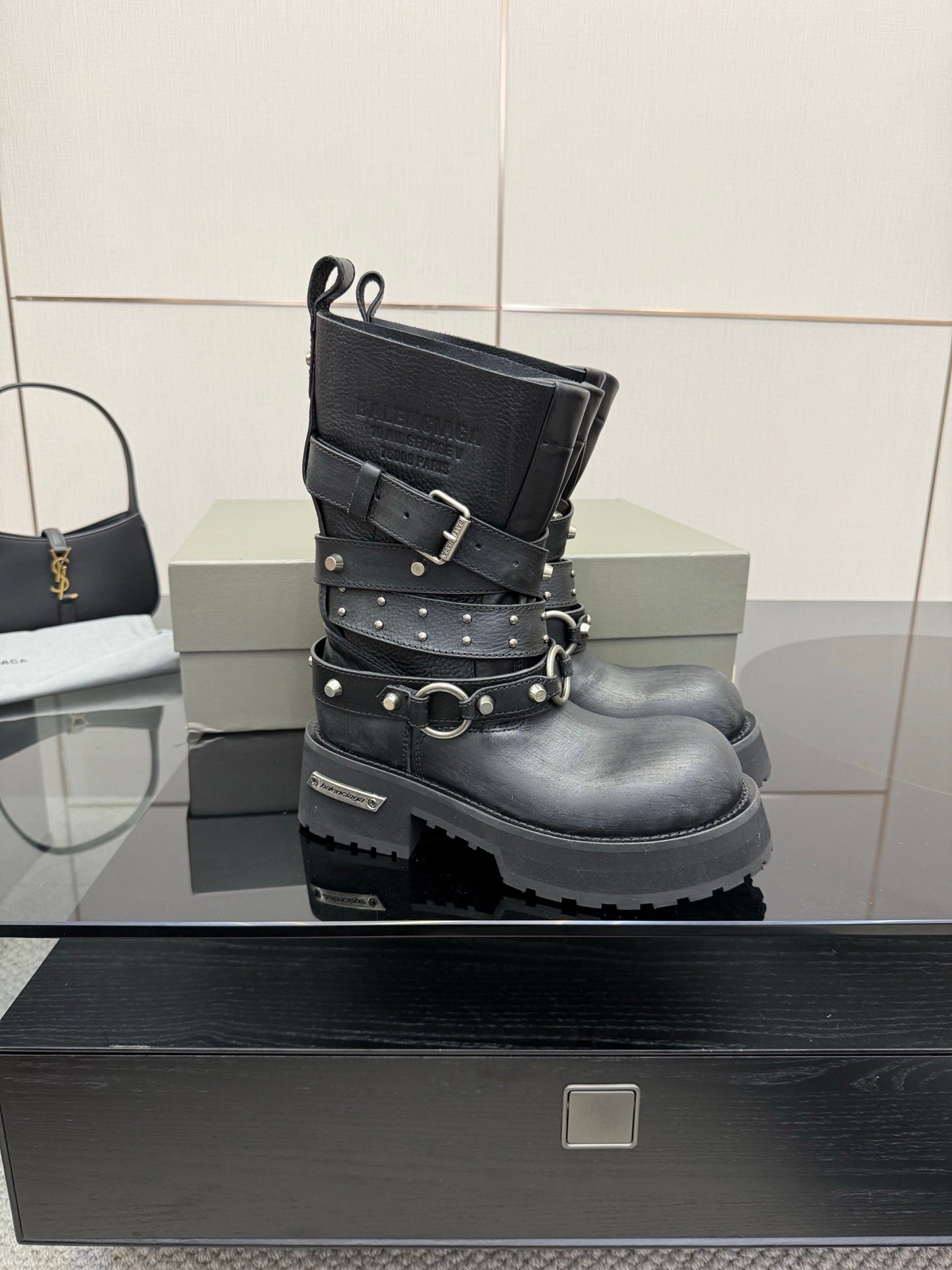 Black studded ankle boots with double straps and circular buckle, front view