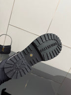 Black lug sole of studded ankle boots with BALENCIAGA lettering