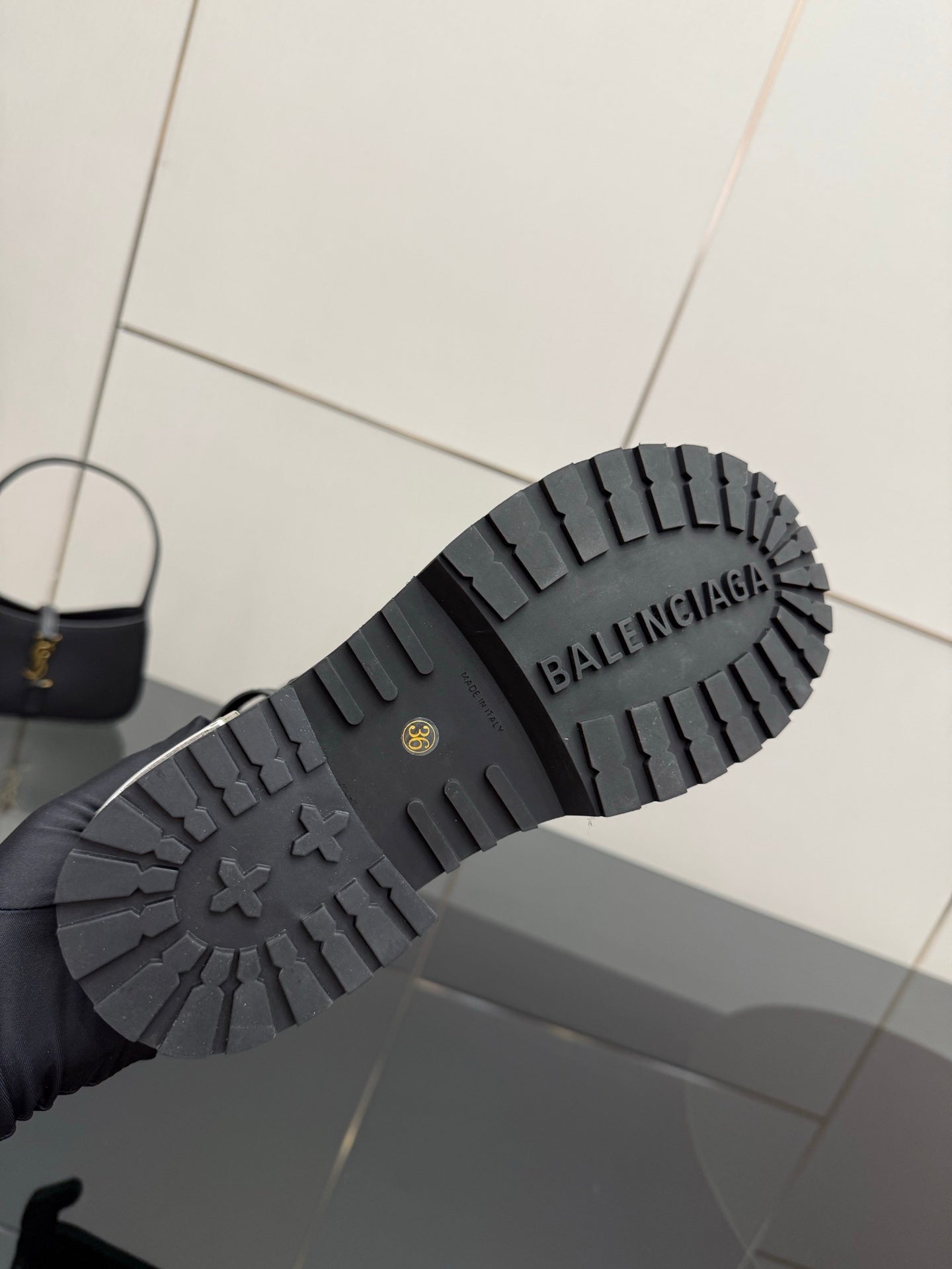 Black lug sole of studded ankle boots with BALENCIAGA lettering
