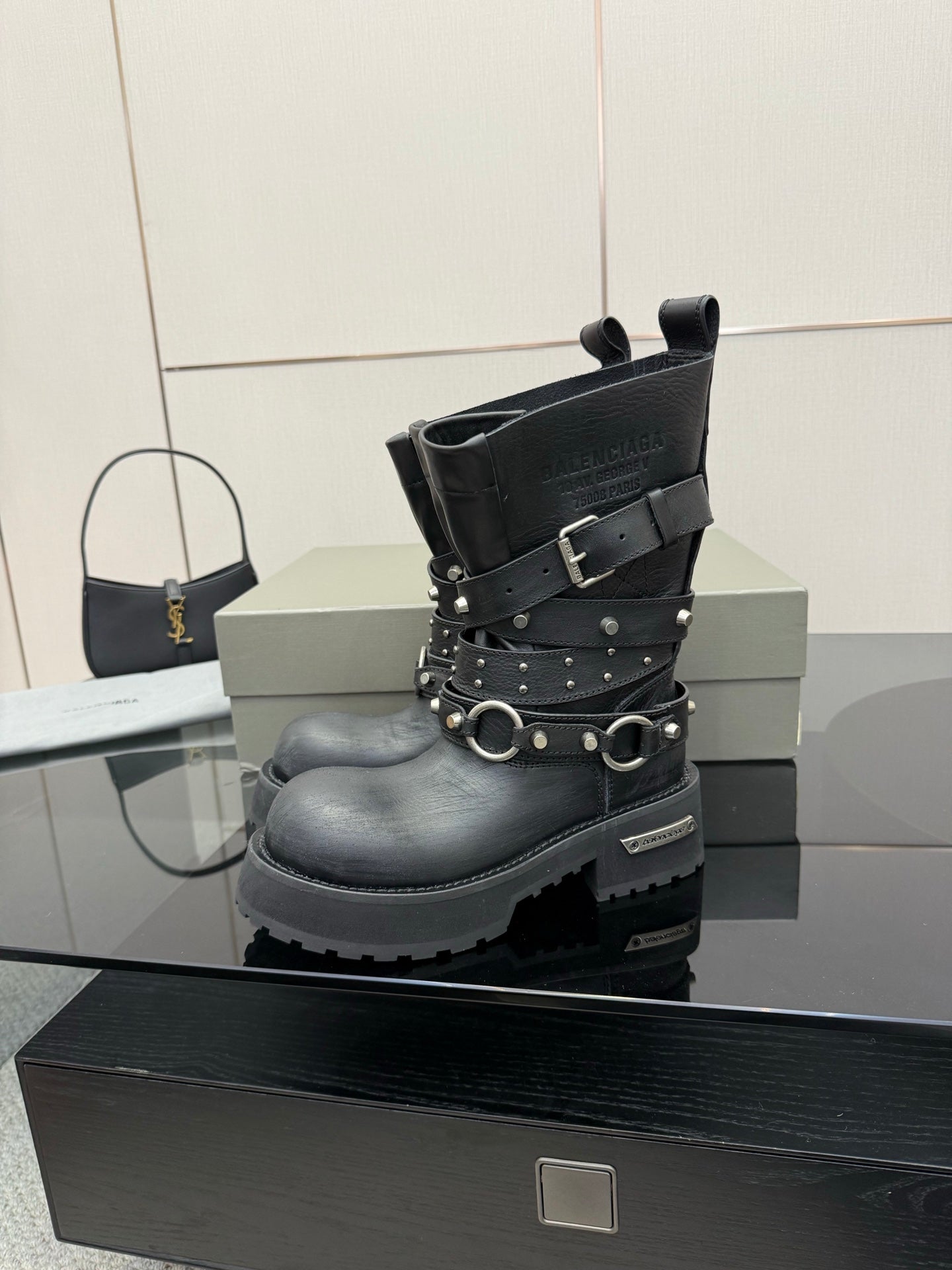 Black studded ankle boot with buckle straps and metal rings, side view