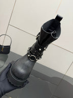 Black ankle boot with studded wrap strap and buckled collar opening