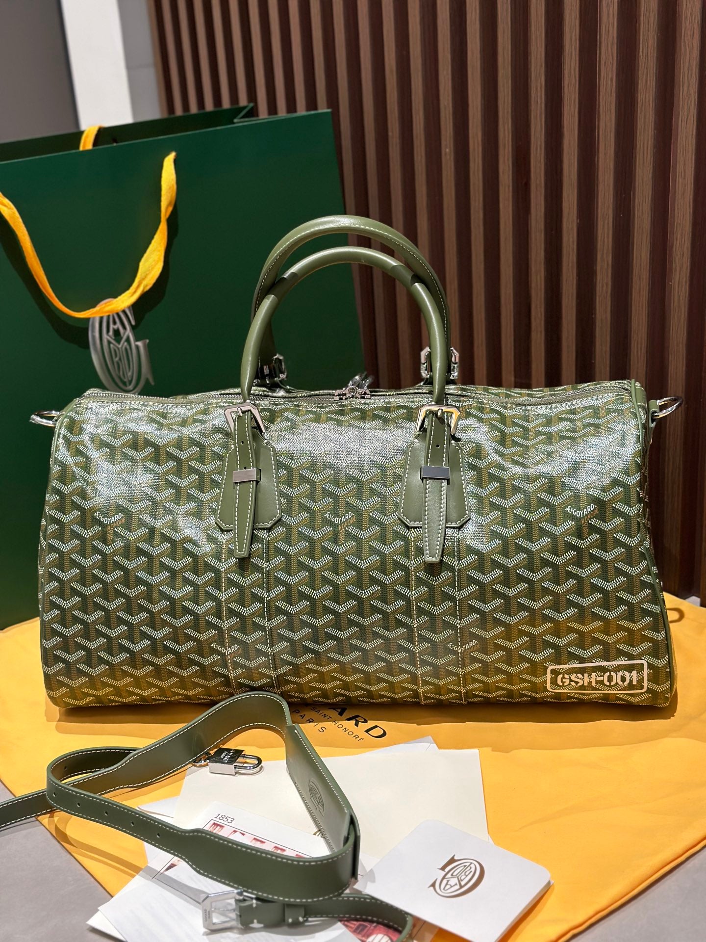 Goyard duffel bag in sage-green Goyardine canvas with top handles and front buckles