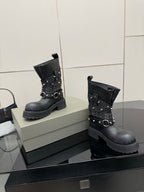 Black ankle boots with layered straps, metal studs, and buckles