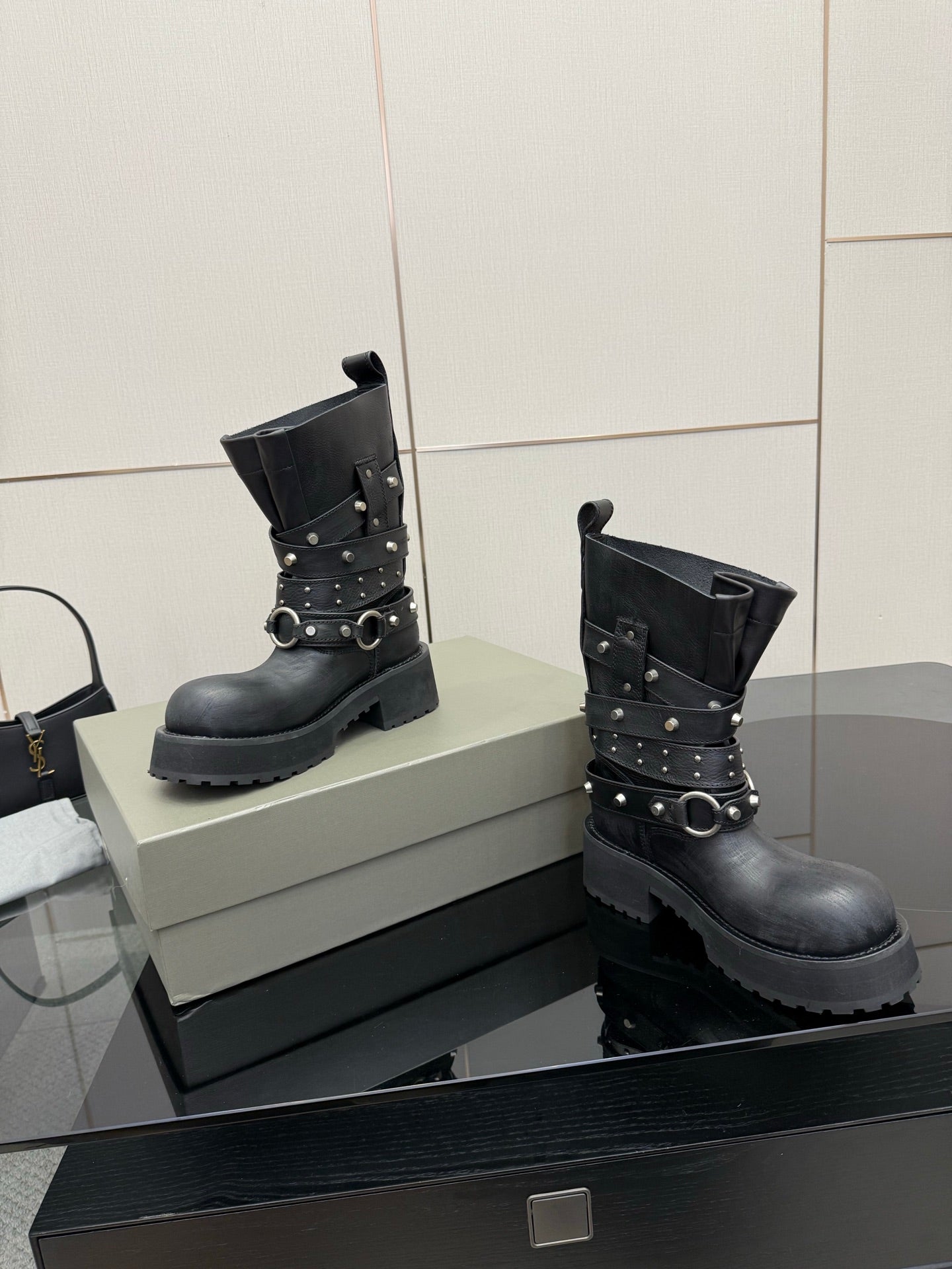 Black ankle boots with layered straps, metal studs, and buckles