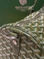 Goyard duffel bag side handle and leather strap with pink-toned buckle hardware