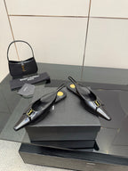 Black pointed-toe slingback heels with gold hardware, angled pair view