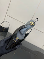 Black slingback heel with gold YSL strap detail, shown close-up