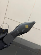 Black slingback heel sole underside with embossed logo and small text