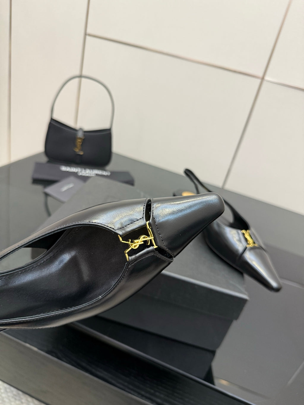 Black leather pointed-toe slingback heel with gold strap detail