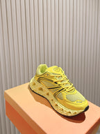 Dior unisex bright yellow low-top sneakers on a light orange box, side view