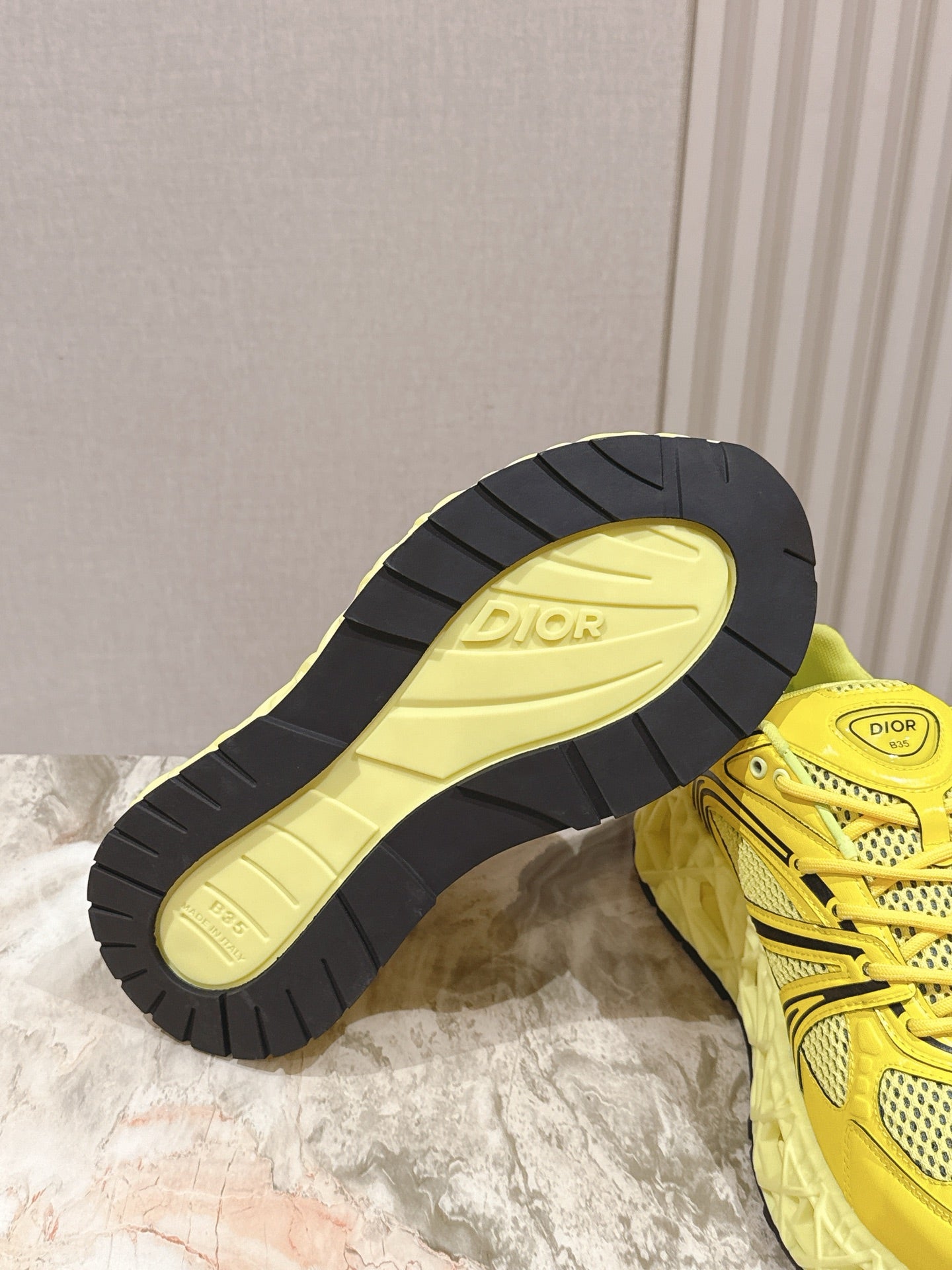 Dior unisex yellow sneakers with black-and-yellow outsole tread visible