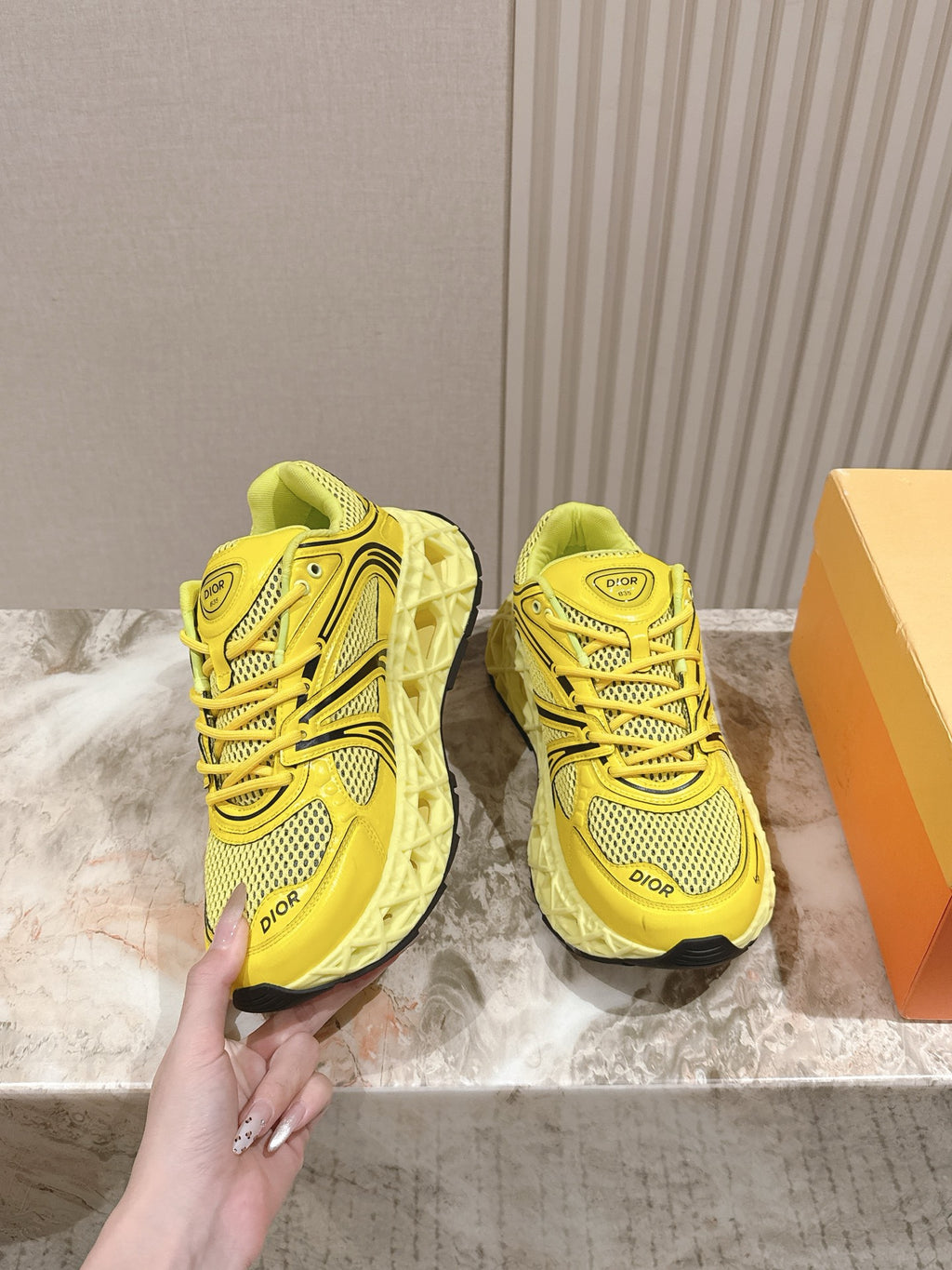 Dior unisex low-top sneakers in bright yellow, side view with lace-up eyelets