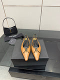 Pair of tan pointed-toe slingback flats with black lining and gold logo hardware