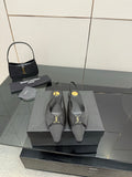Women's black pointed-toe slingback heels with gold logo detail, stiletto heel