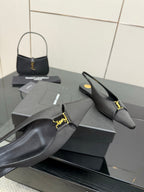 Women's black slingback pointed-toe heel with gold logo strap detail and curved toe