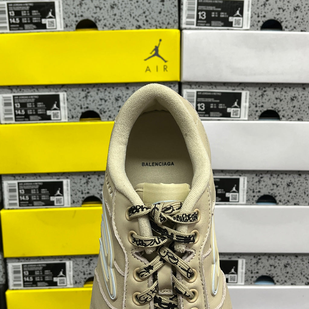 Beige Balenciaga sneaker with BALENCIAGA text on heel and lace-up upper