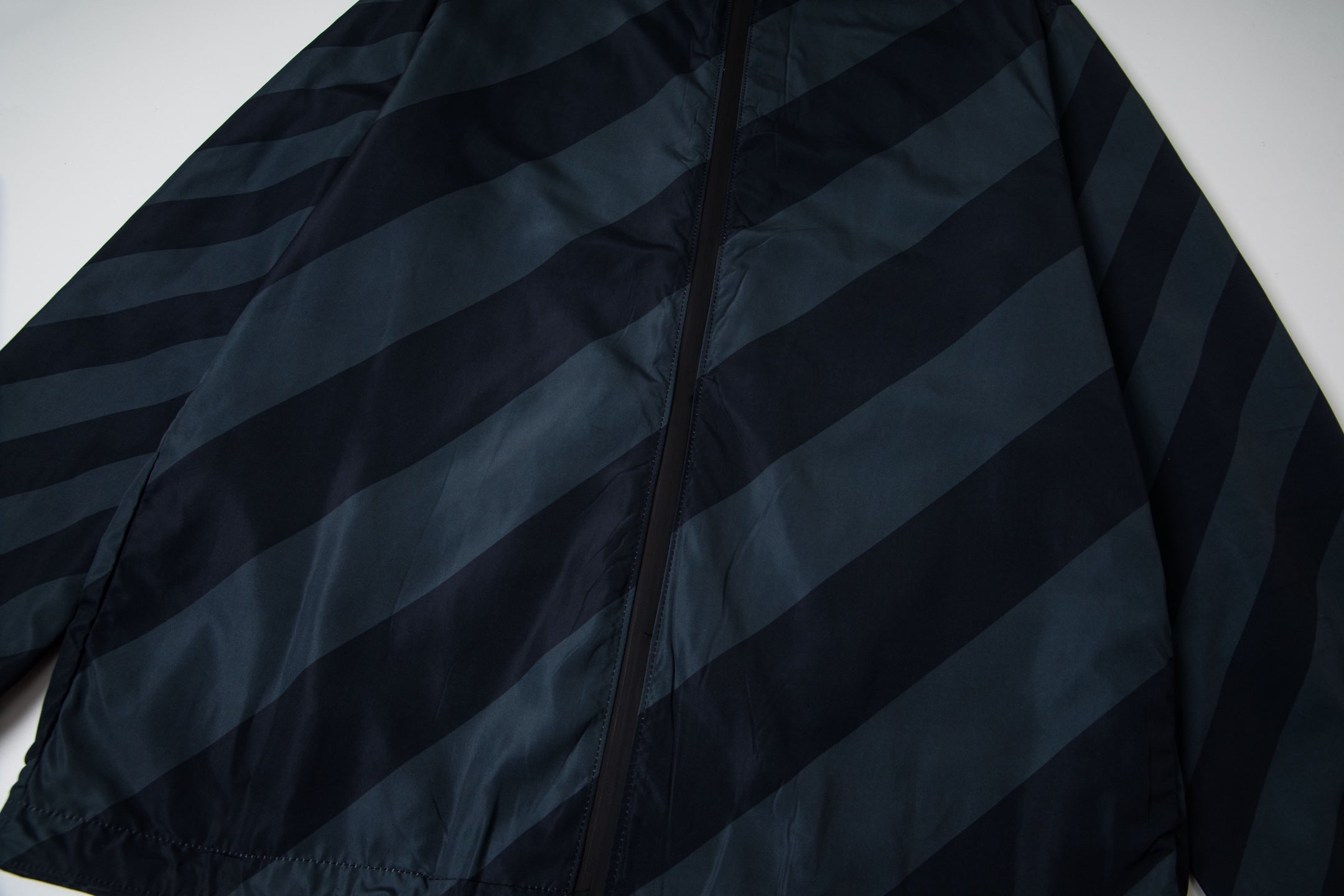 Fendi long hooded jacket front detail with dark blue diagonal stripes and central zipper