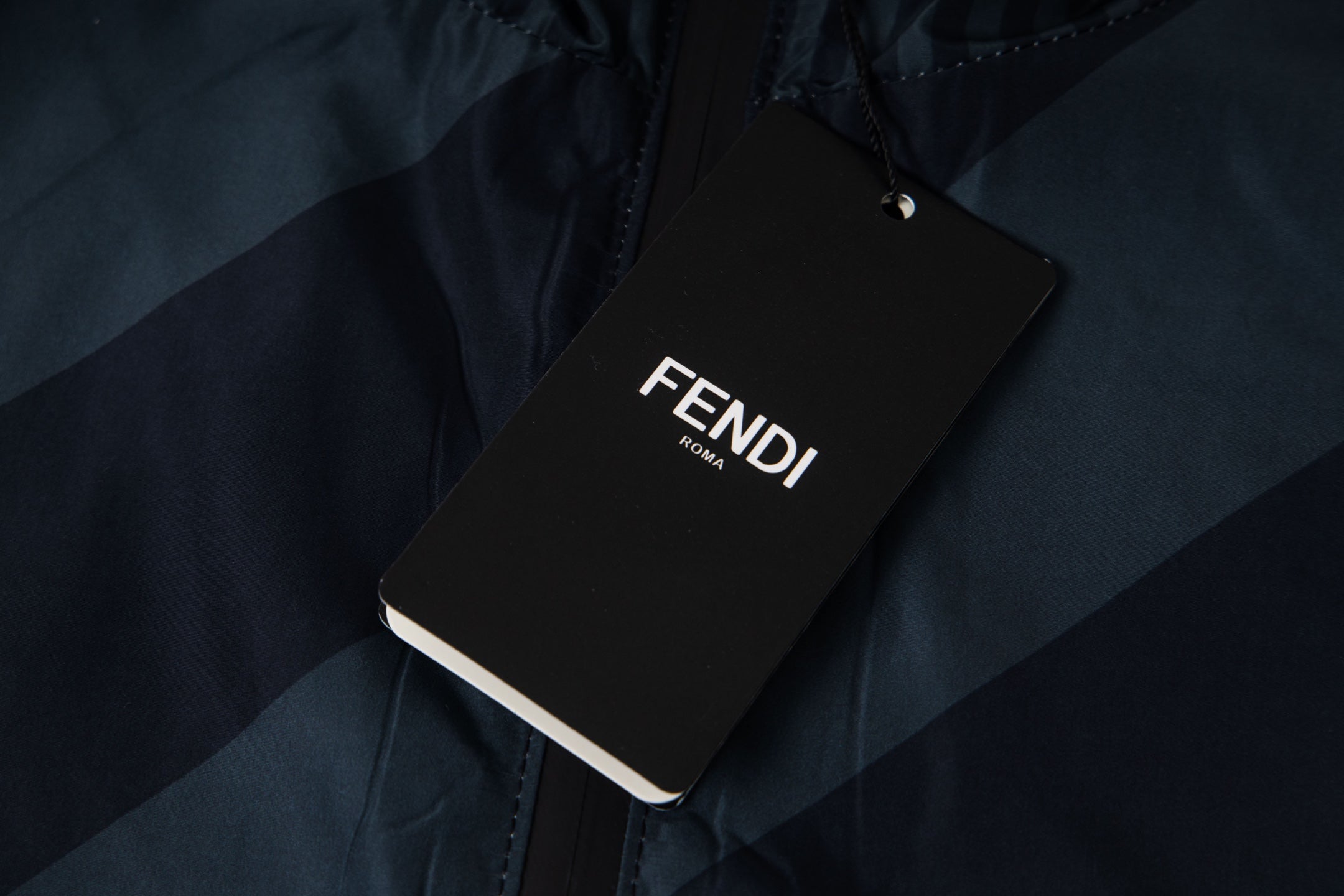 Fendi long hooded jacket with FENDI brand tag attached on dark blue fabric