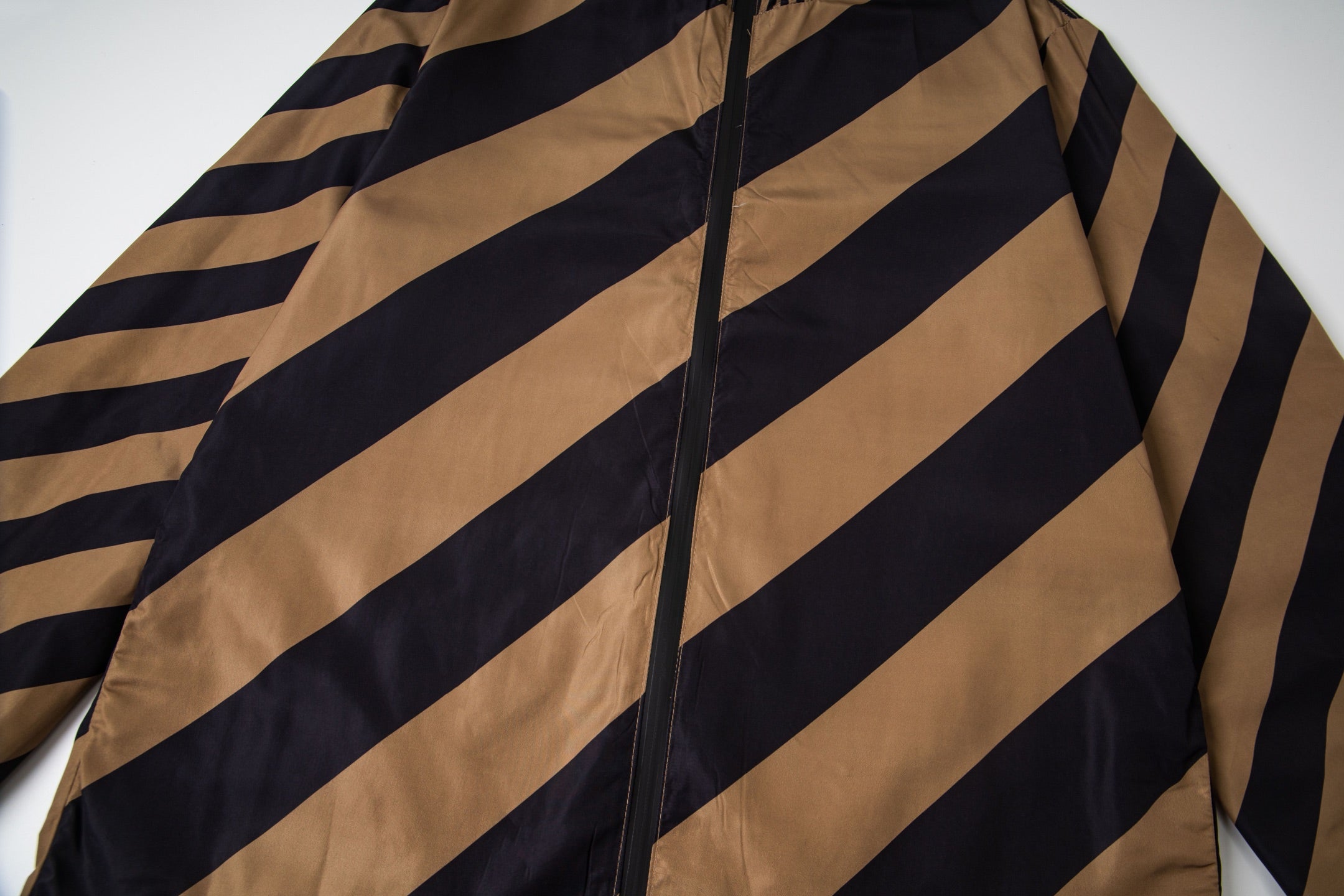 Fendi long jacket close-up of diagonal tan and navy stripes with black zipper