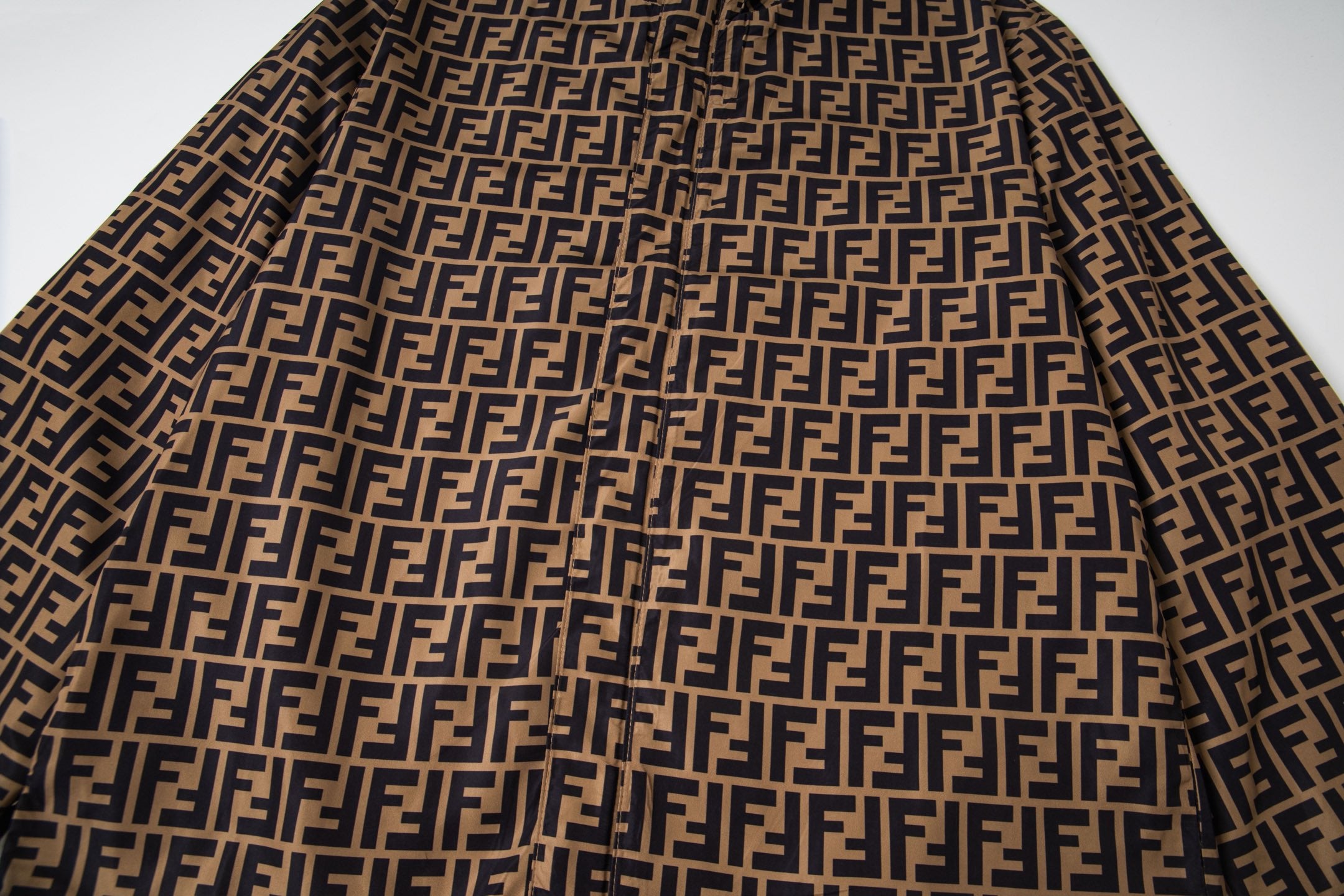 Fendi hooded jacket fabric with repeating FF logo pattern, dark and tan
