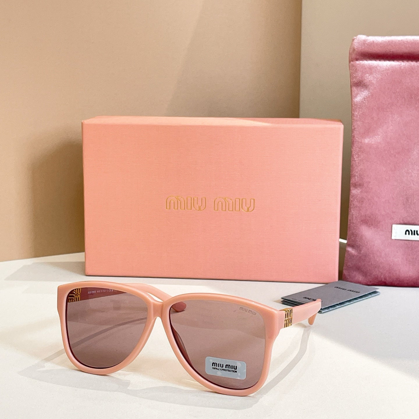 MiuMiu sunglasses with light pink frames and dark brown lenses