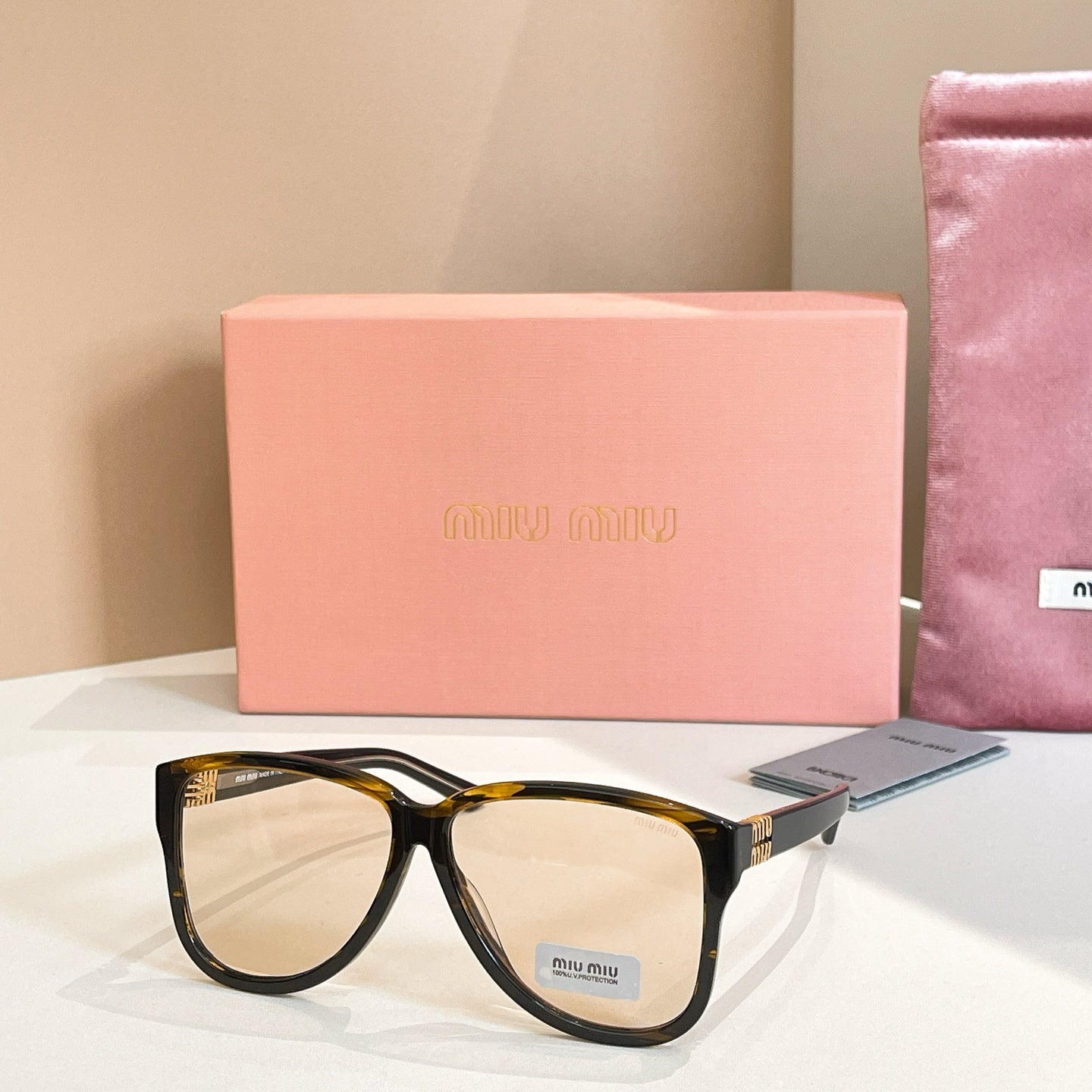 MiuMiu sunglasses with dark tortoiseshell frames and light lenses