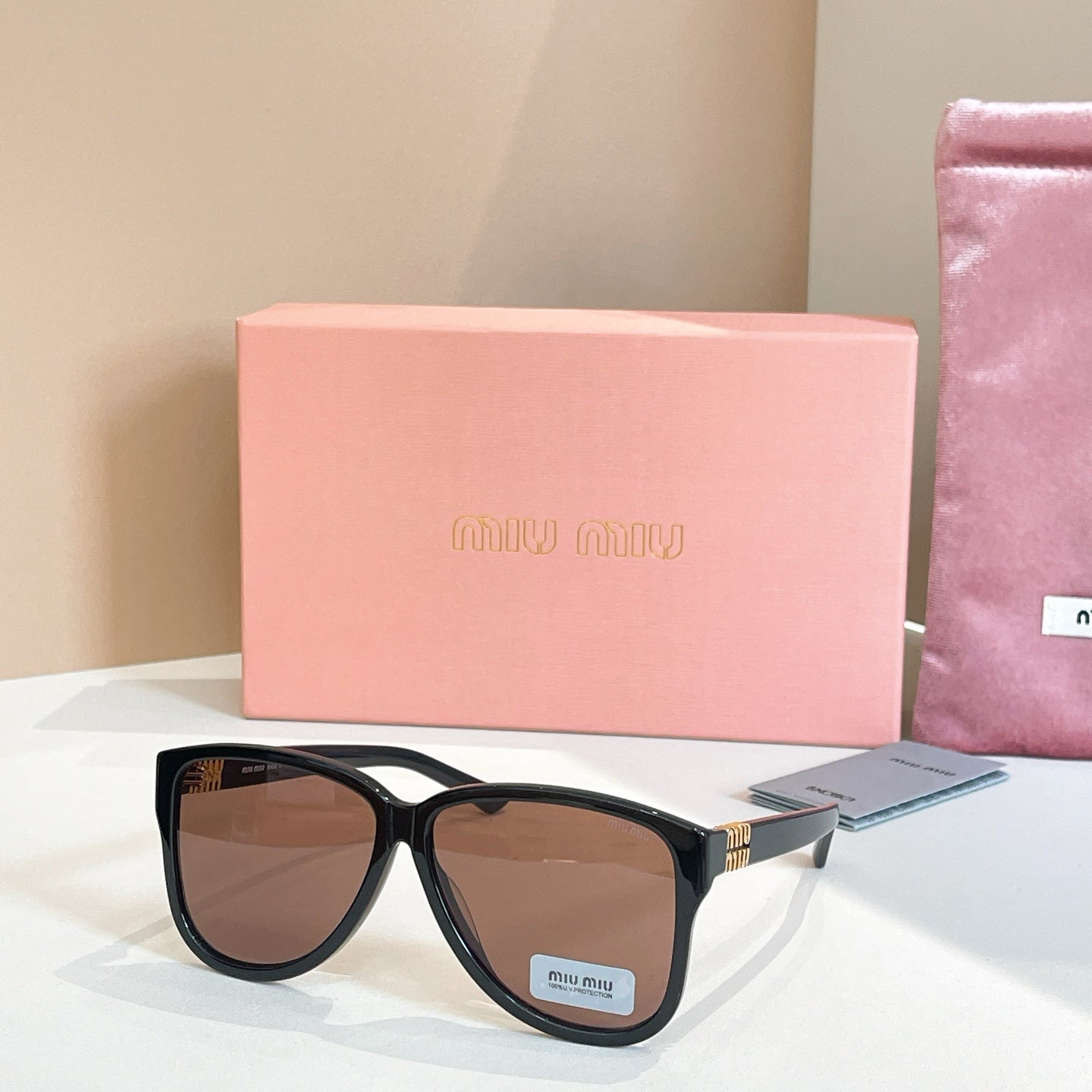 MiuMiu sunglasses with black frames and dark brown lenses