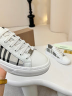 Lace-up low-top sneakers with white uppers and black-and-cream check stripe