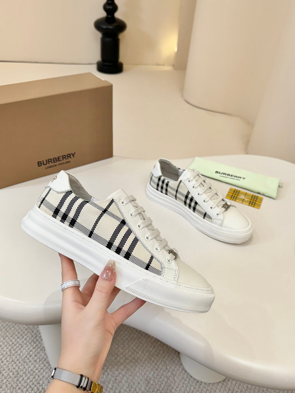 Pair of lace-up low-top sneakers with white uppers and black-and-cream check panels