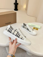 Pair of lace-up low-top sneakers with white uppers and black-and-cream check panels