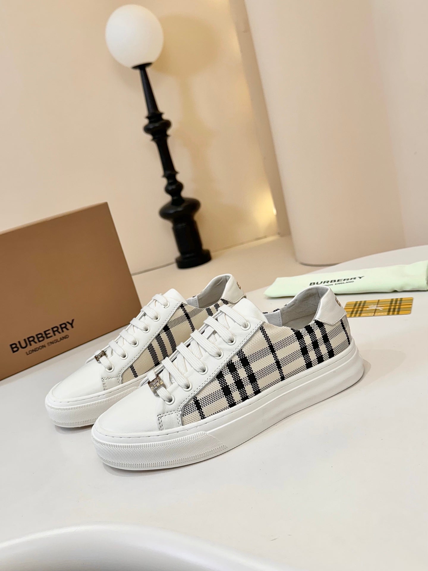 Low-top sneakers with white uppers and black-and-cream check side panels