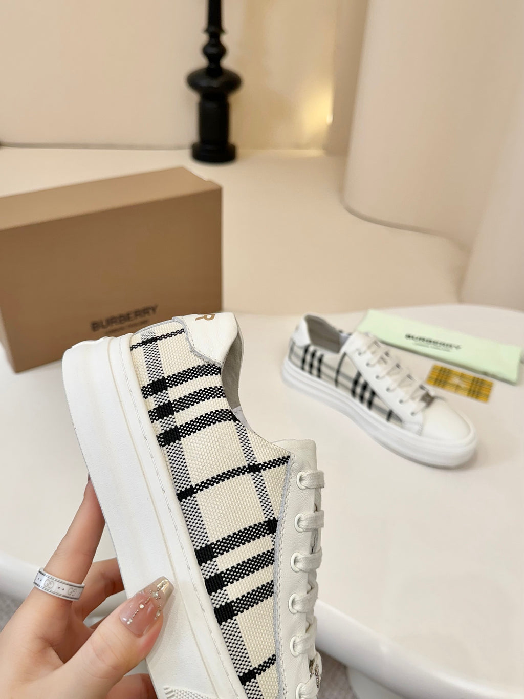 Side view of check-panel low-top sneakers in white with lace-up detail