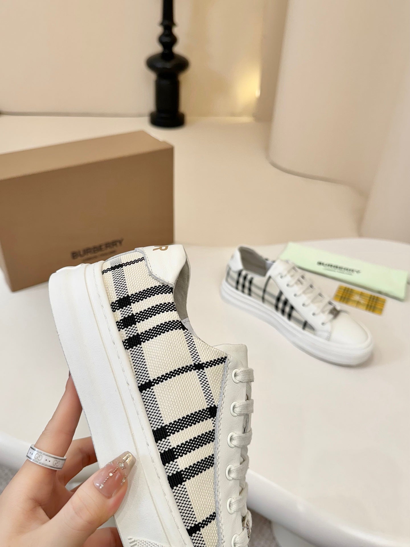 Side view of check-panel low-top sneakers in white with lace-up detail