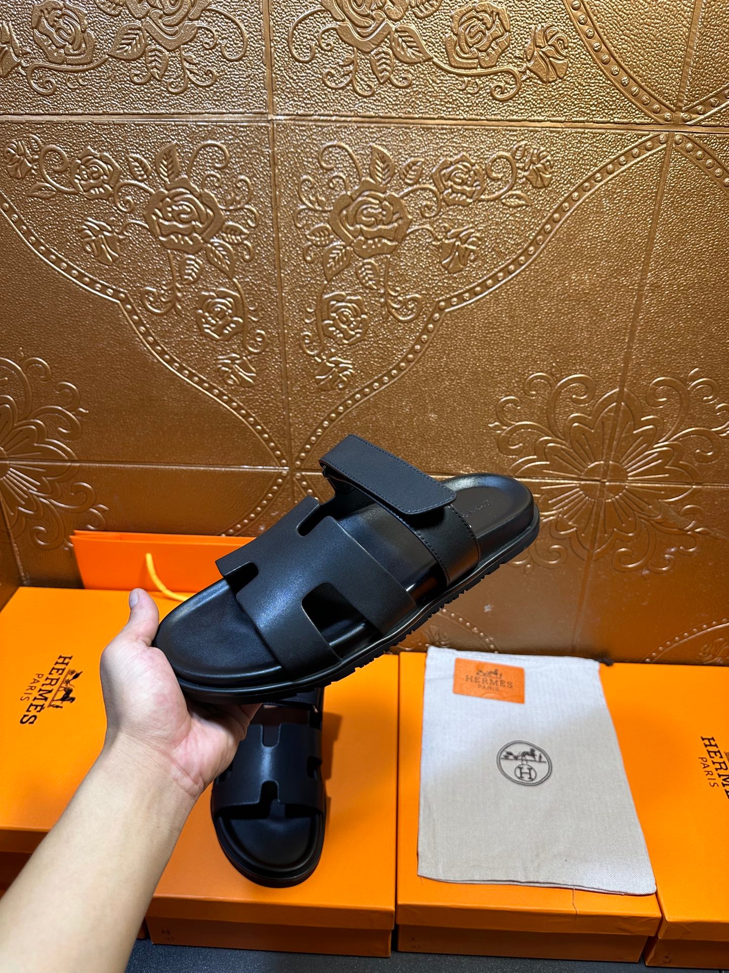 Hermes dark leather slide sandals with thick straps, side profile view