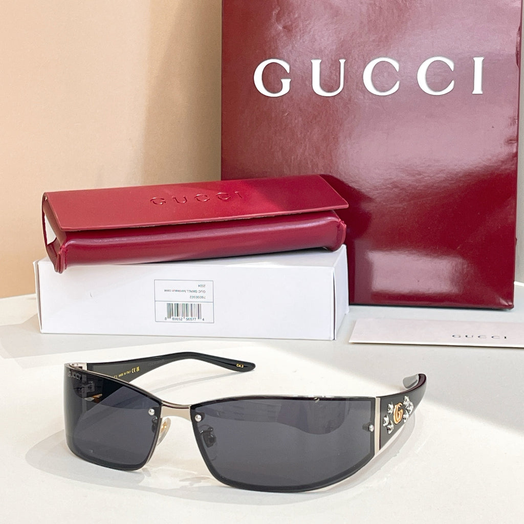 Black sunglasses with dark lenses and gold side crest