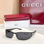Black sunglasses with dark lenses and gold emblem detailing