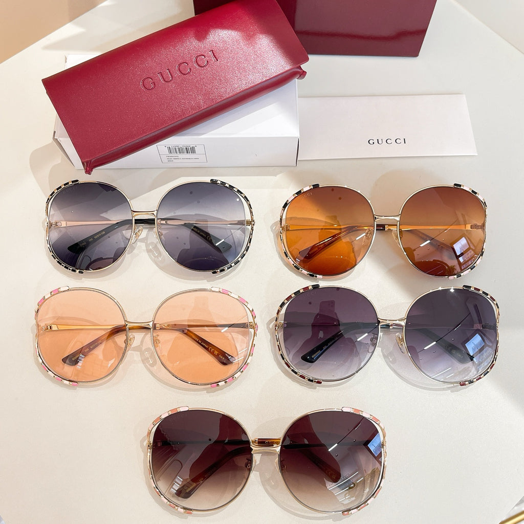 Assorted Gucci round sunglasses with tinted lenses and mixed gold and patterned frames