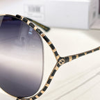 Gucci sunglasses side view with black-and-gold patterned temple and logo detail