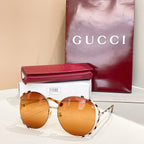 Gucci round sunglasses with amber orange lenses, gold frame, and patterned temples
