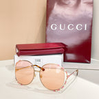 Gucci round sunglasses with pink-tinted lenses, gold frame, and patterned temples